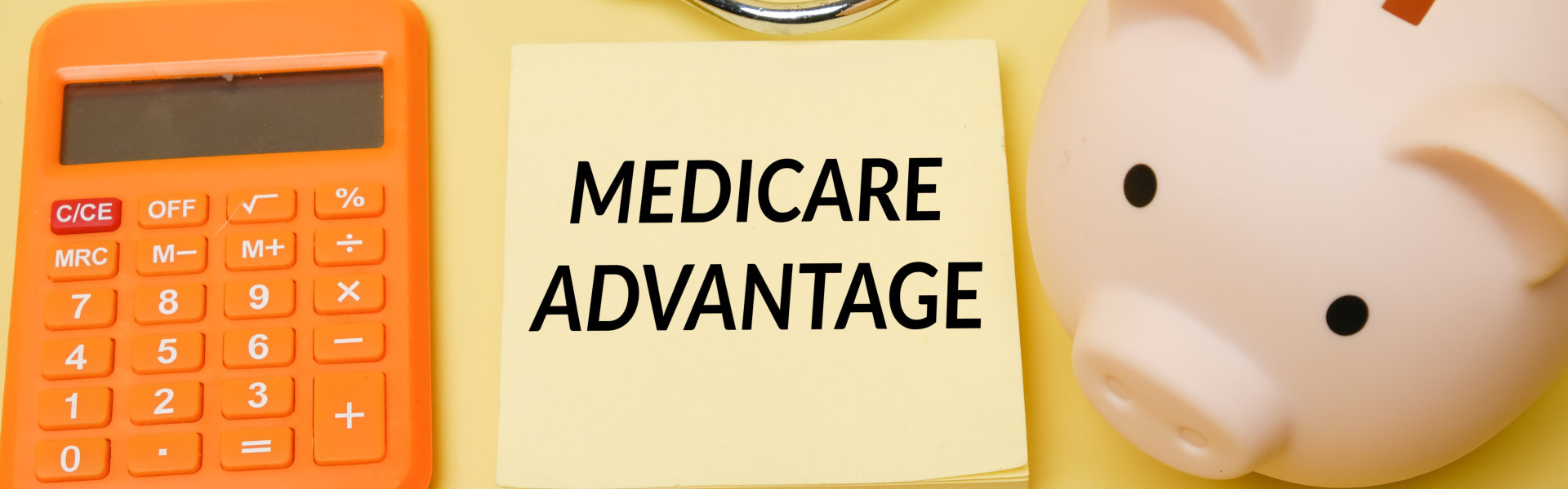 medicare advantage text on sticky notes with piggy bank and calculator